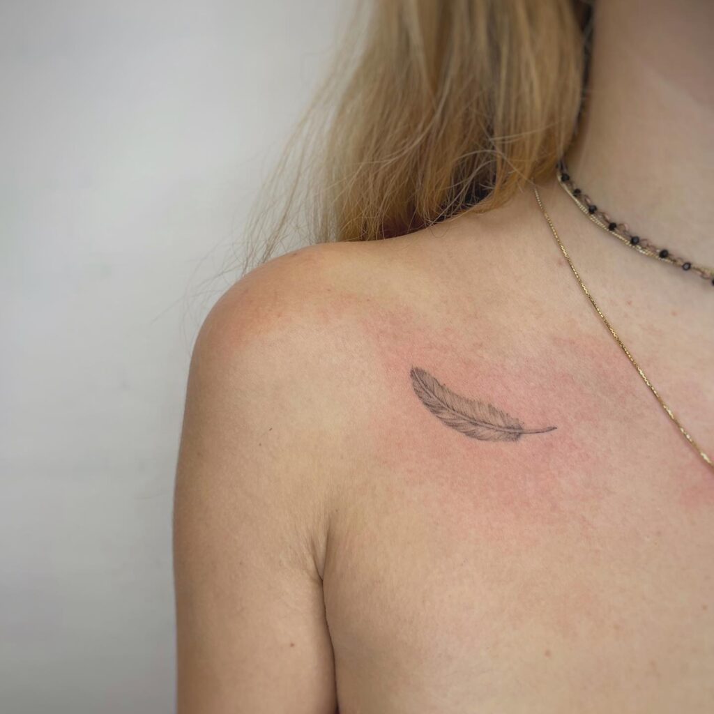 Feathered whimsy delicate feather tattoo on the collarbone