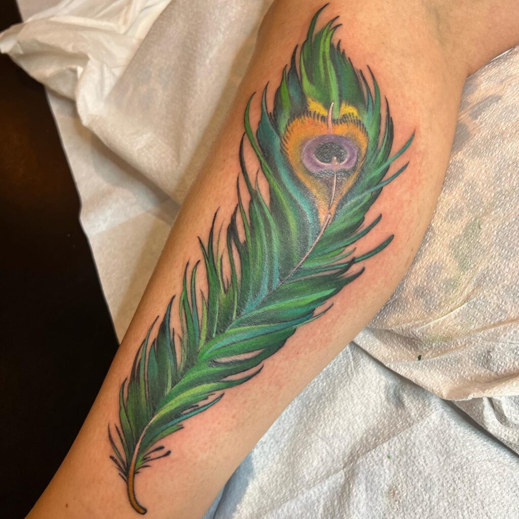 Feathers of elegance peacock feather tattoo on the side calf for women