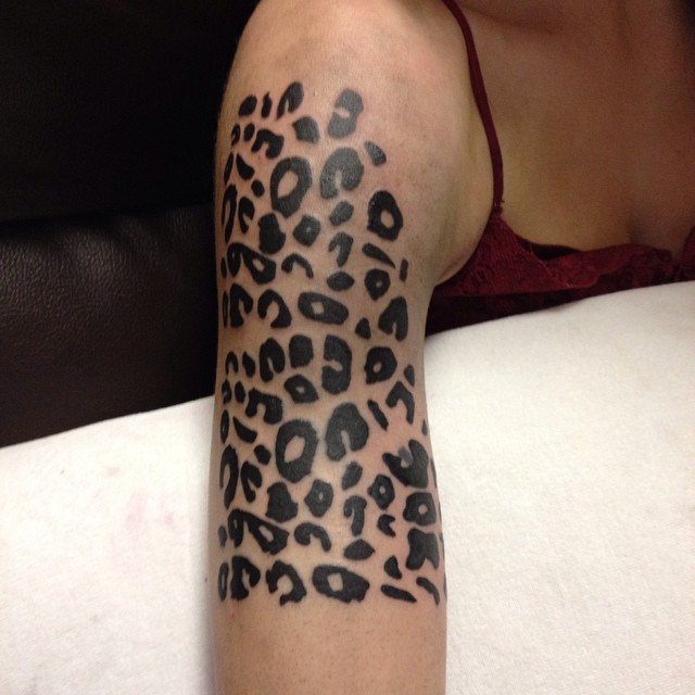 Female black leopard print shoulder tattoo a bold choice