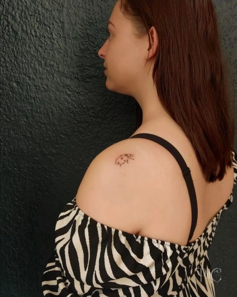 Feminine Ladybug Tattoo on Arm Shoulder: Stylish and Graceful Design