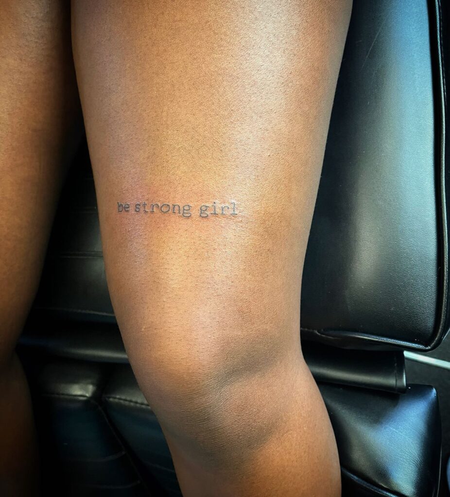 Finding strength beyond words be strong text tattoo above the knee