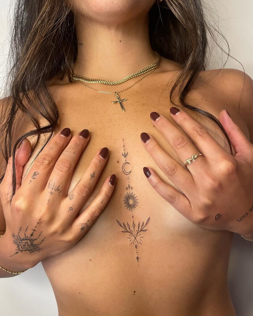 Fine-line celestial botanical sternum tattoo with moon and sun