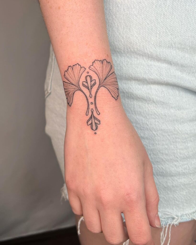 Fine line ginkgo leaves tattoo on the outer wrist elegant and detailed