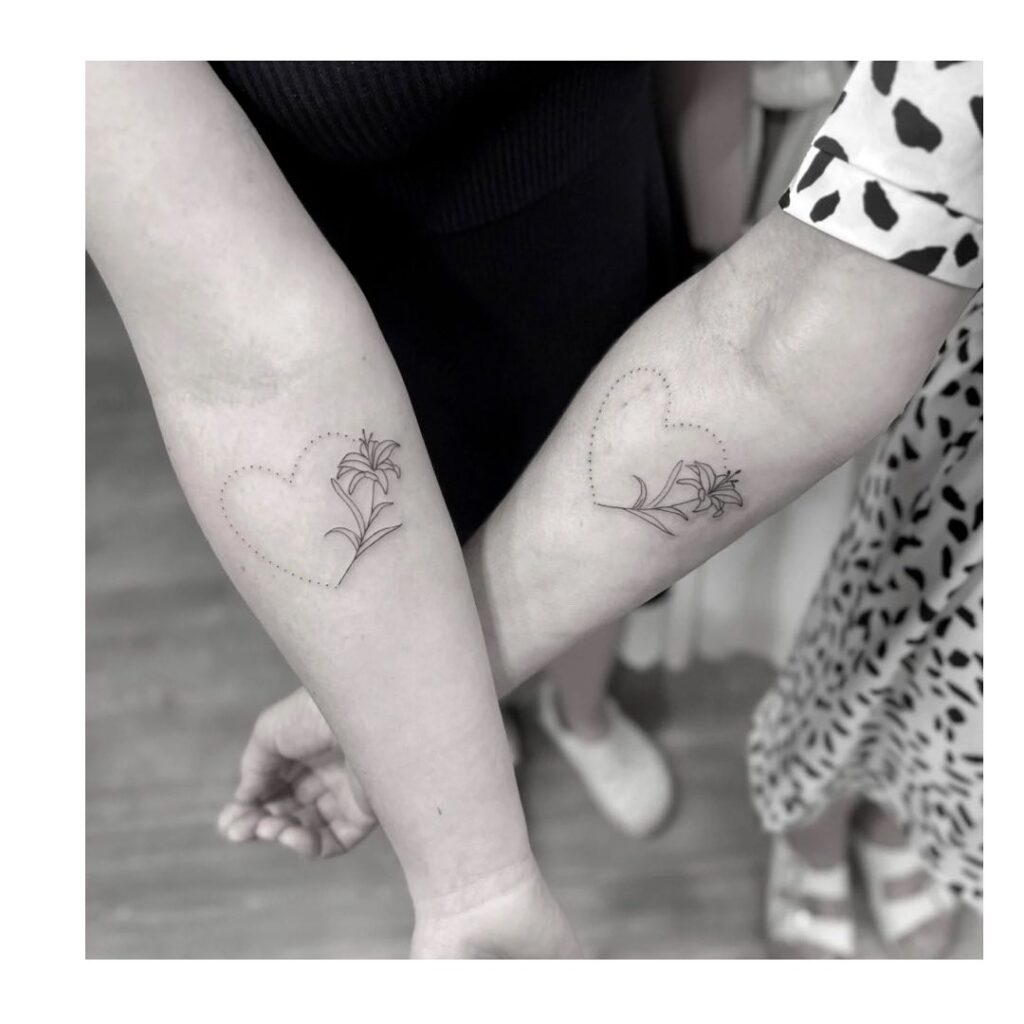 Fine-line heart and floral forearm tattoo representing an unbreakable mother-daughter bond