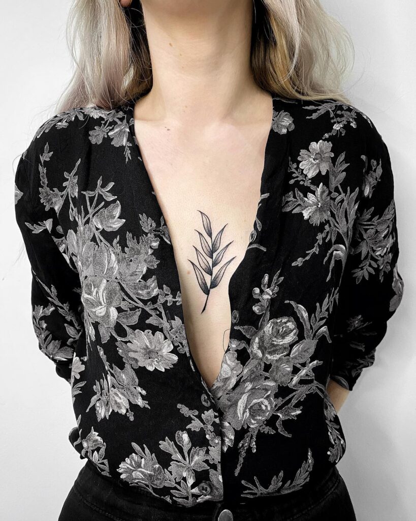 Fine-line leaf sternum tattoo elegant nature-inspired chest design