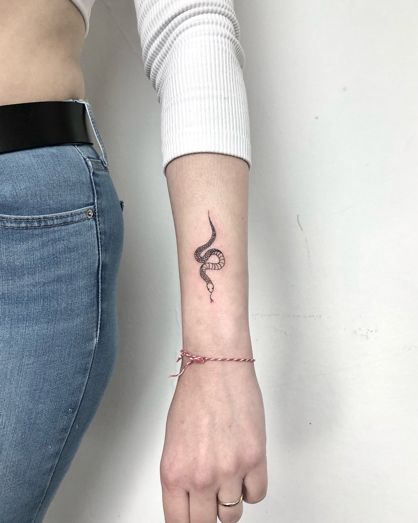 Fine-Line Snake Tattoo on Inner Wrist Sleek and Intricate Design