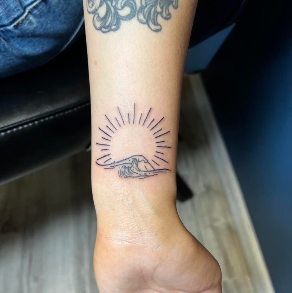 Fine line sun and wave tattoo wrist elegance