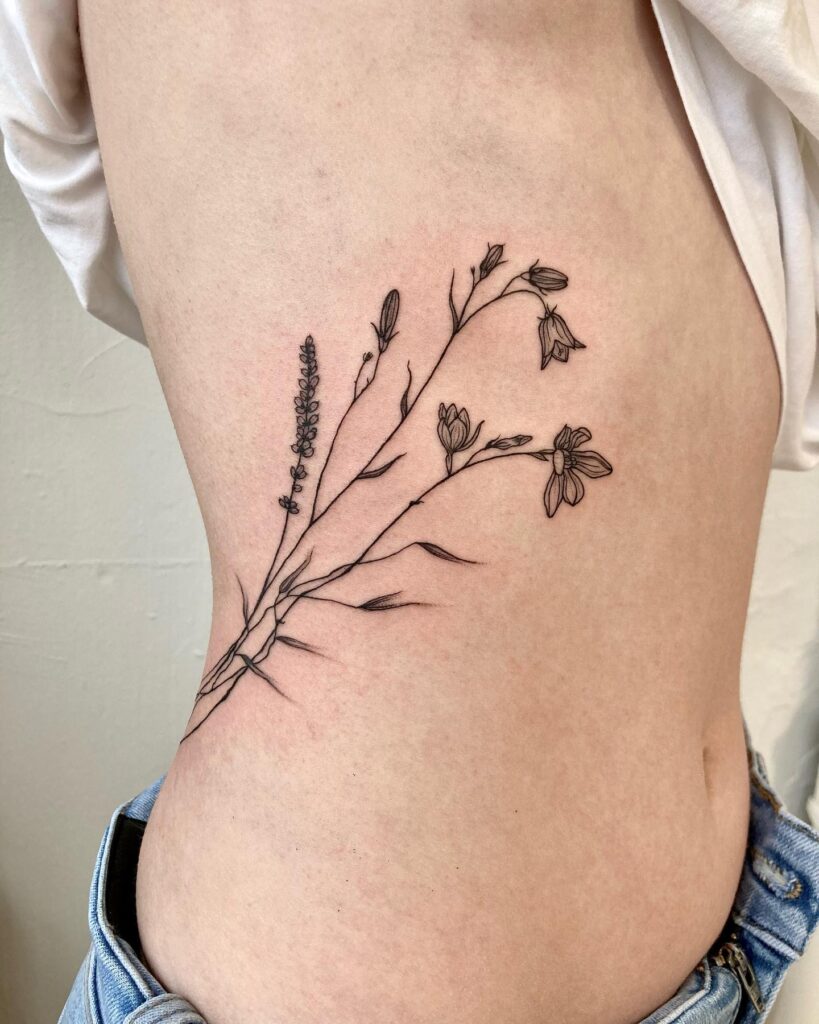 Fineline bluebell flower tattoo on waist delicate and subtle