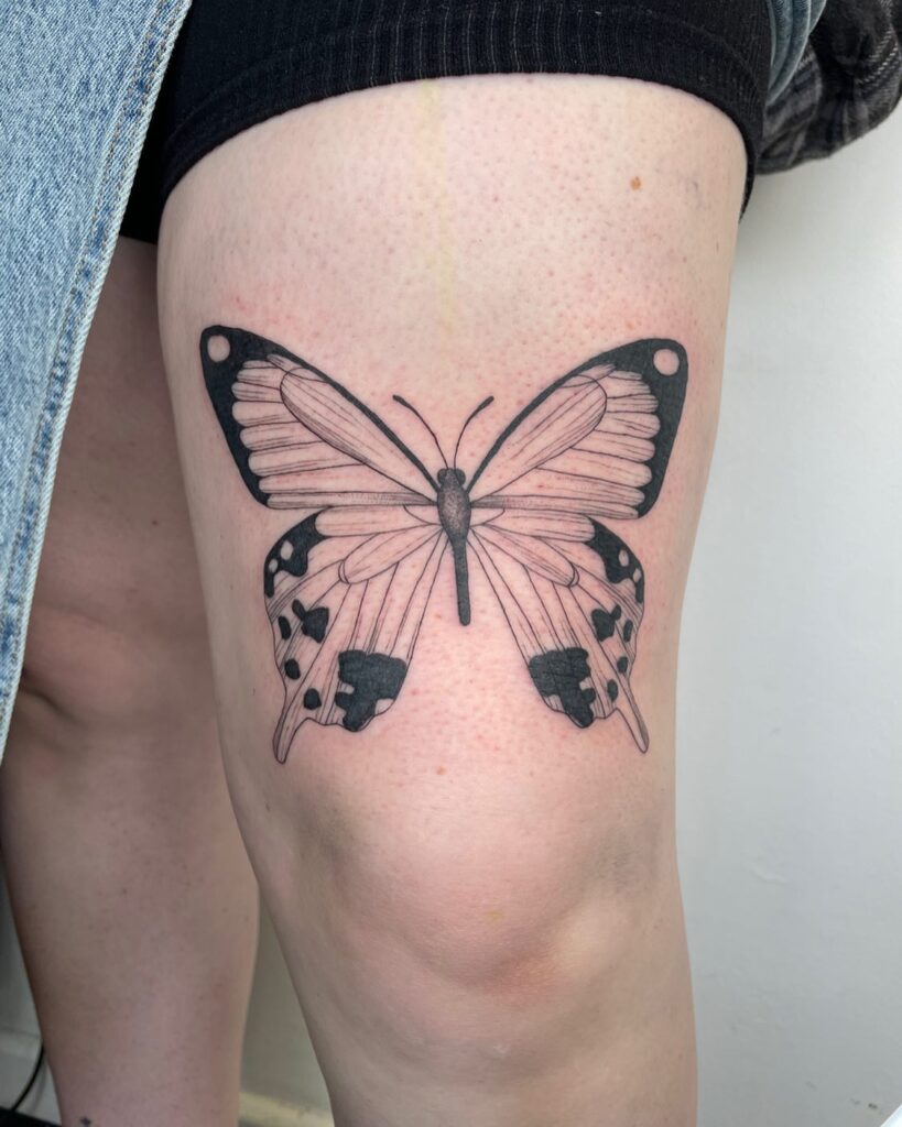 Fineline butterfly tattoo on thigh a delicate flutter