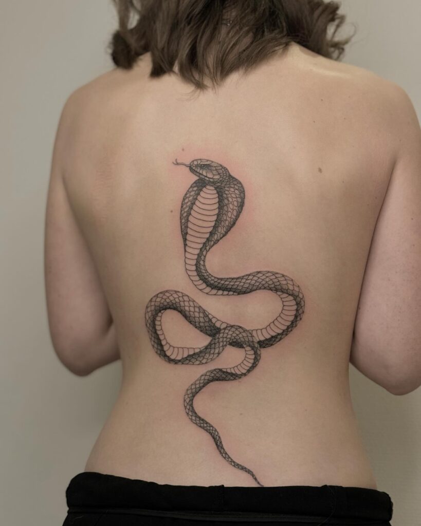 Fineline cobra tattoo for females on the back, elegant with tongue out: delicate venom