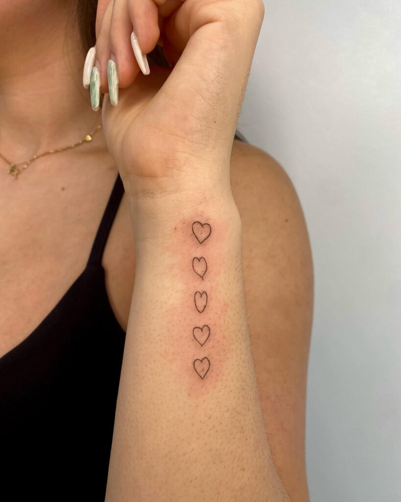 Fineline love vertically aligned outline hearts on outer wrist