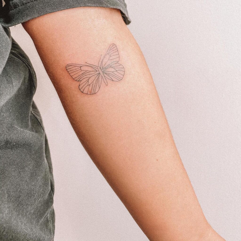 Fineline minimal butterfly tattoo on the forearm for a delicate and feminine look: butterfly ballet