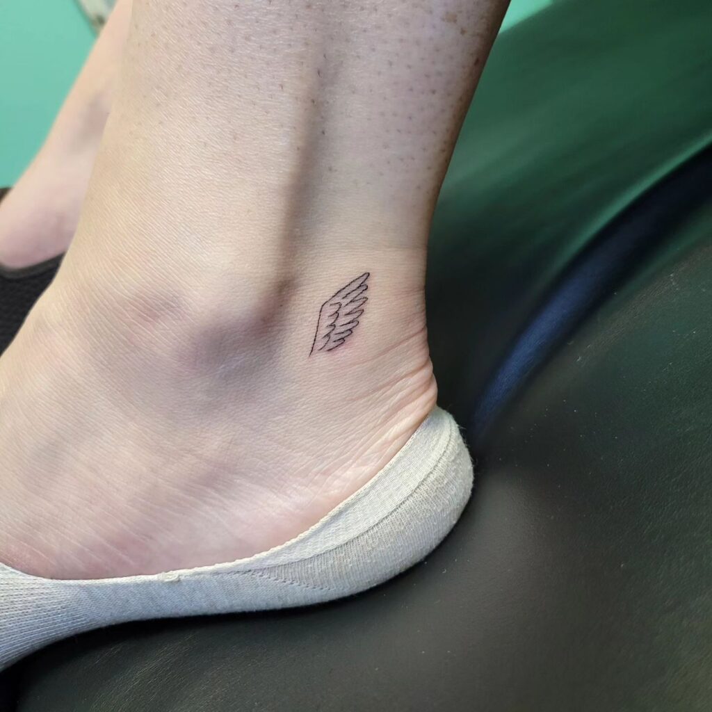 Fineline Side View Wing Tattoo Near the Ankle: Airborne Grace