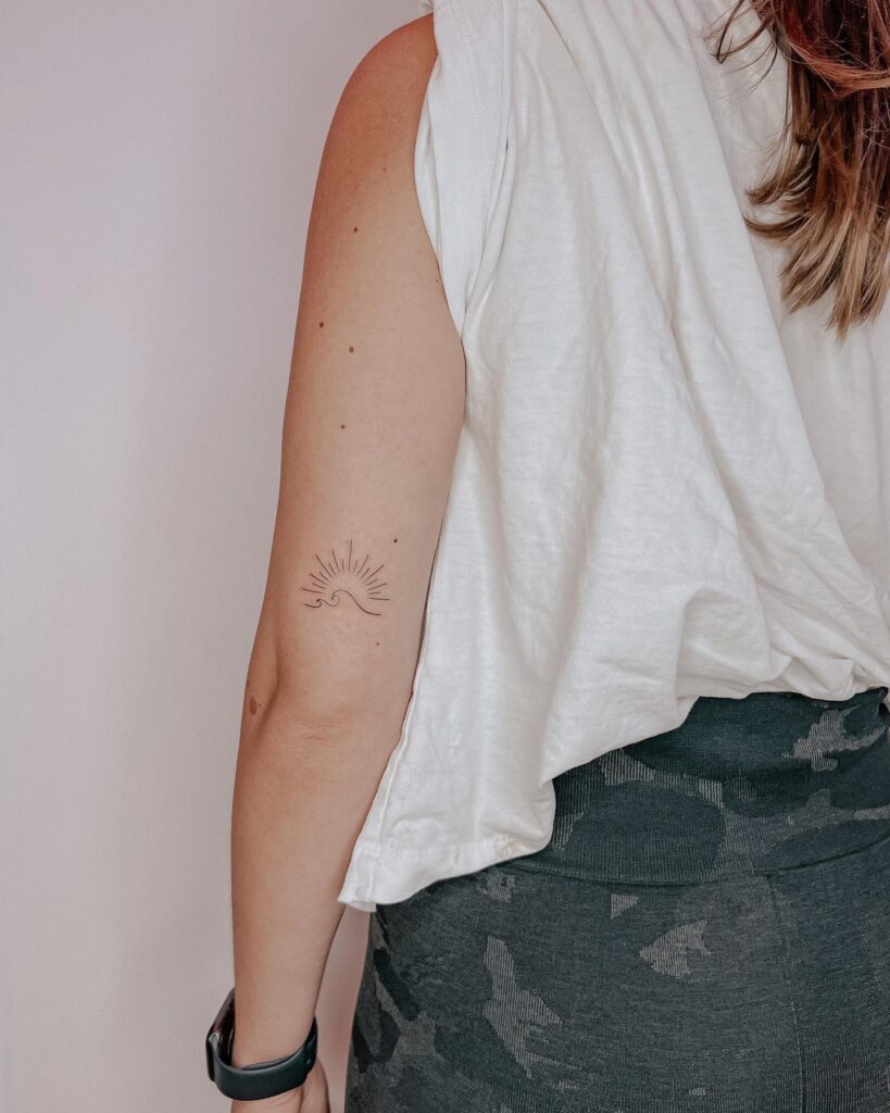 Fineline Sun and Wave Tattoo, Adorning the Back of the Above Elbow: Sunset Serenity