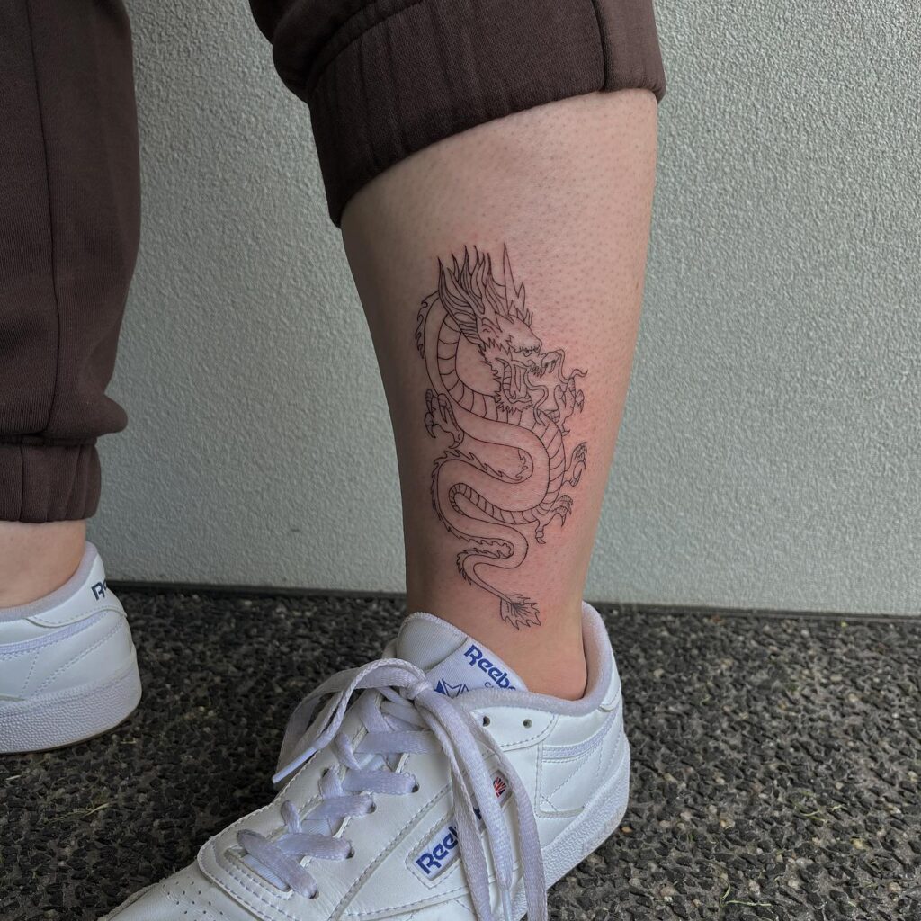 Fineline Tiny Dragon Tattoo on the Leg, a Subtle Mythical Presence: Dragon Whispers