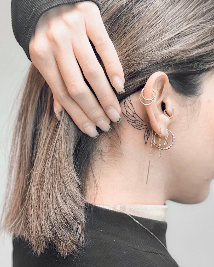 Fineline Wing Tattoo Behind the Ear, a Small Elegance: Subtle Flight