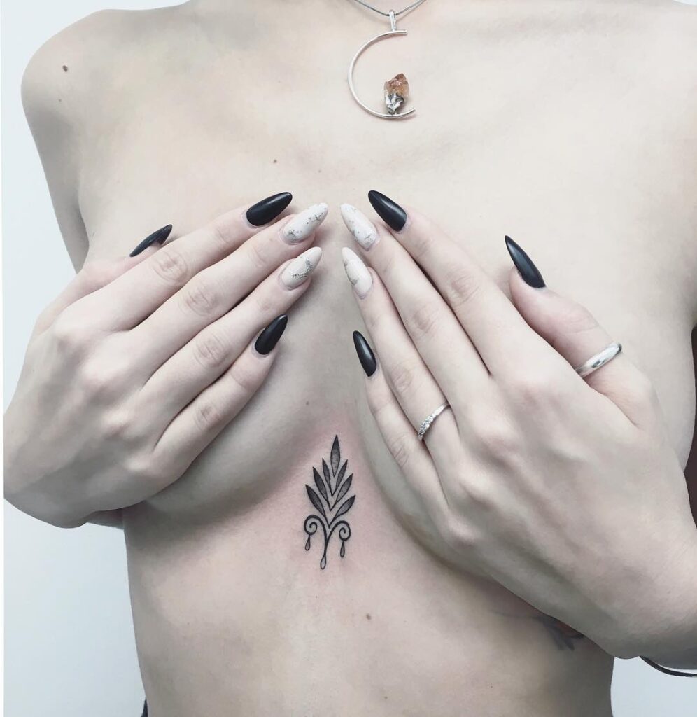 Fleur-de-lis ornamental sternum tattoo symmetrical and decorative design