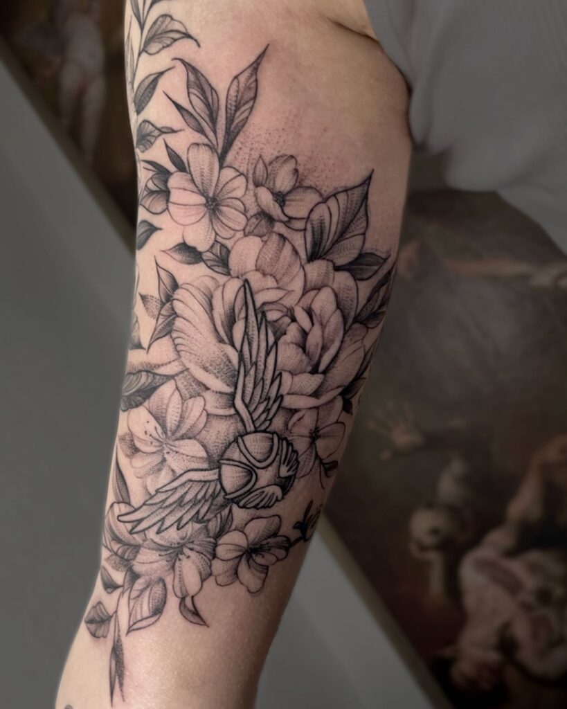 Floral Enchantment Golden Snitch Harry Potter Tattoo With Flowers on the Arm