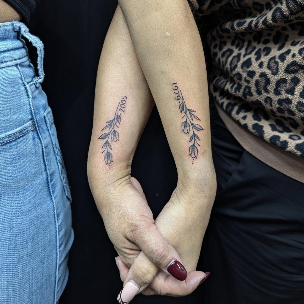 Floral birth year tattoo on forearm for parent and child