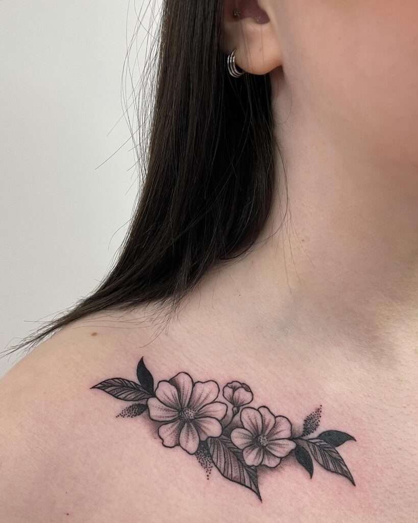 Floral blackwork collarbone tattoo, a delicate and intricate design botanical beauty