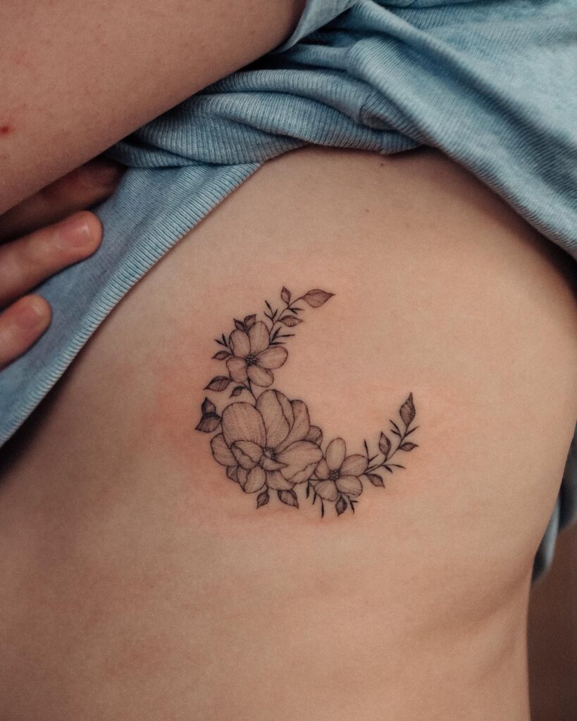 Floral tattoo blooming on the rib, adding a touch of nature's elegance-blossom beauty