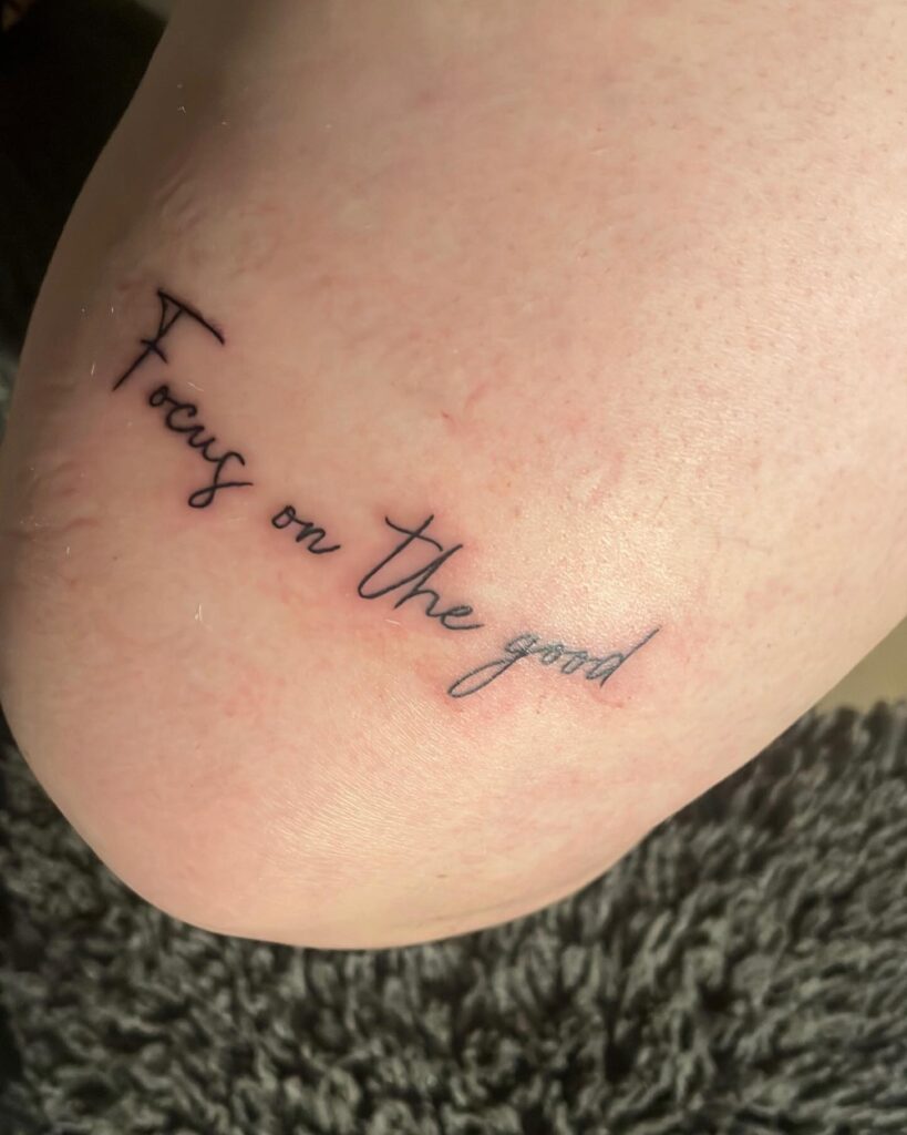 "Focus on the Good" Text Tattoo: Inspirational Above Knee Ink