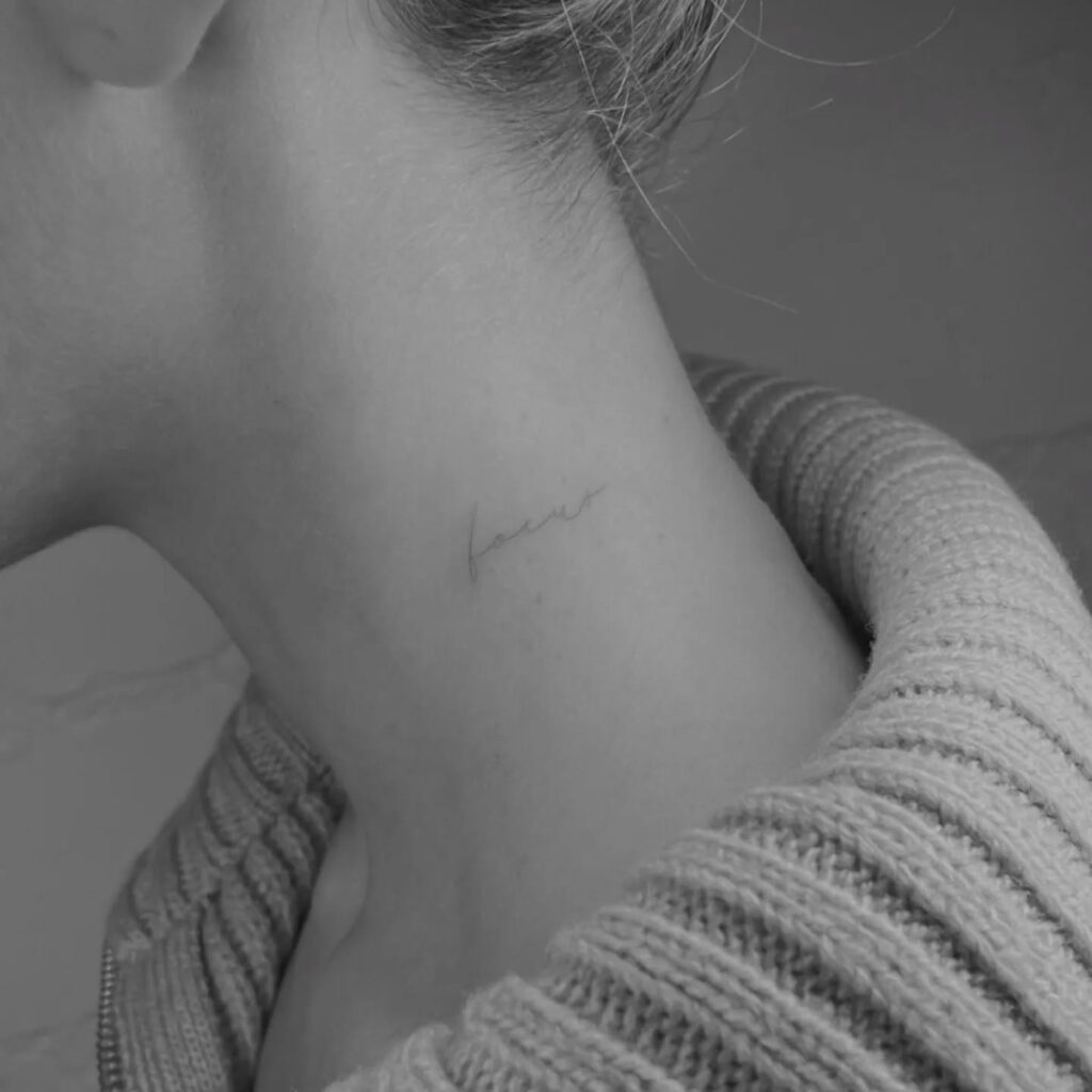 Focus tattoo in handwritten script on the neck for motivation