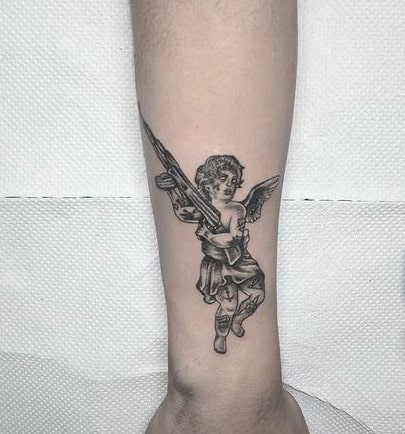Forearm shaded angel with gun tattoo for boys and girls Forearm shaded angel with gun tattoo for boys and girls