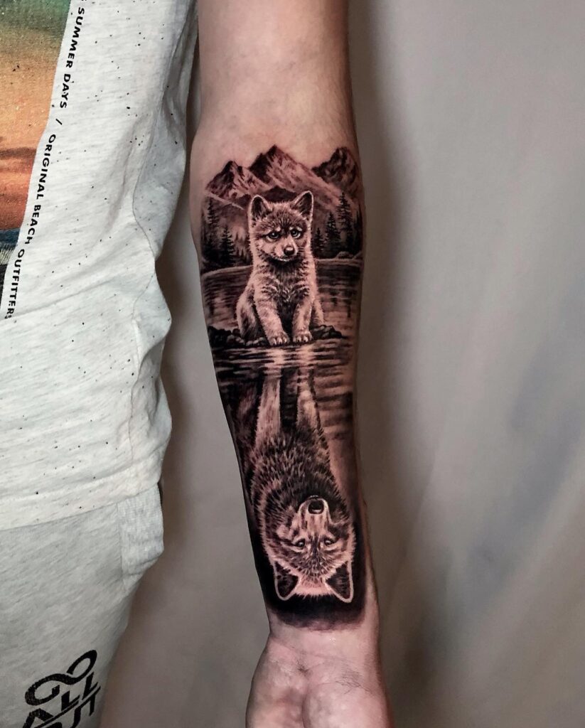 Forearm tattoo inspiration realistic wolf puppy gazing at its reflection