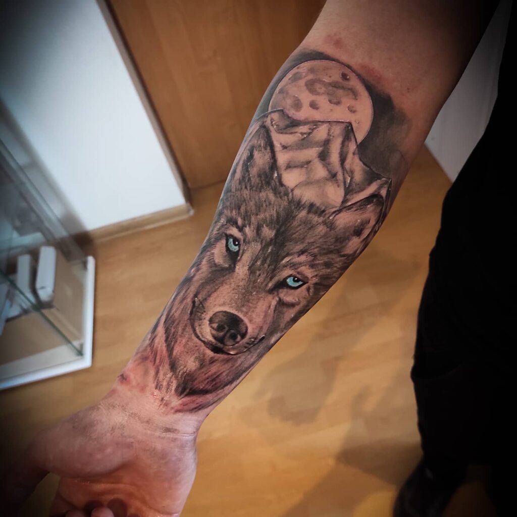 Forearm wolf tattoo blue eyes