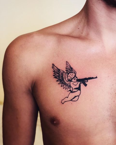 Front chest angel with gun tattoo