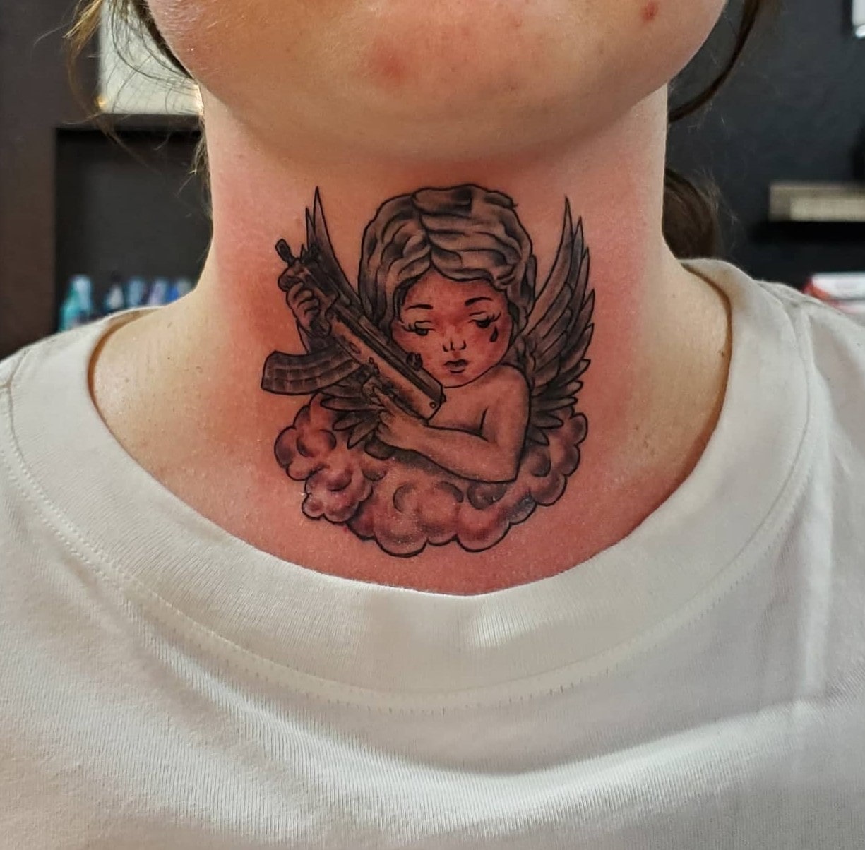 Front neck angel with gun tattoo for men and women Front neck angel with gun tattoo for men and women