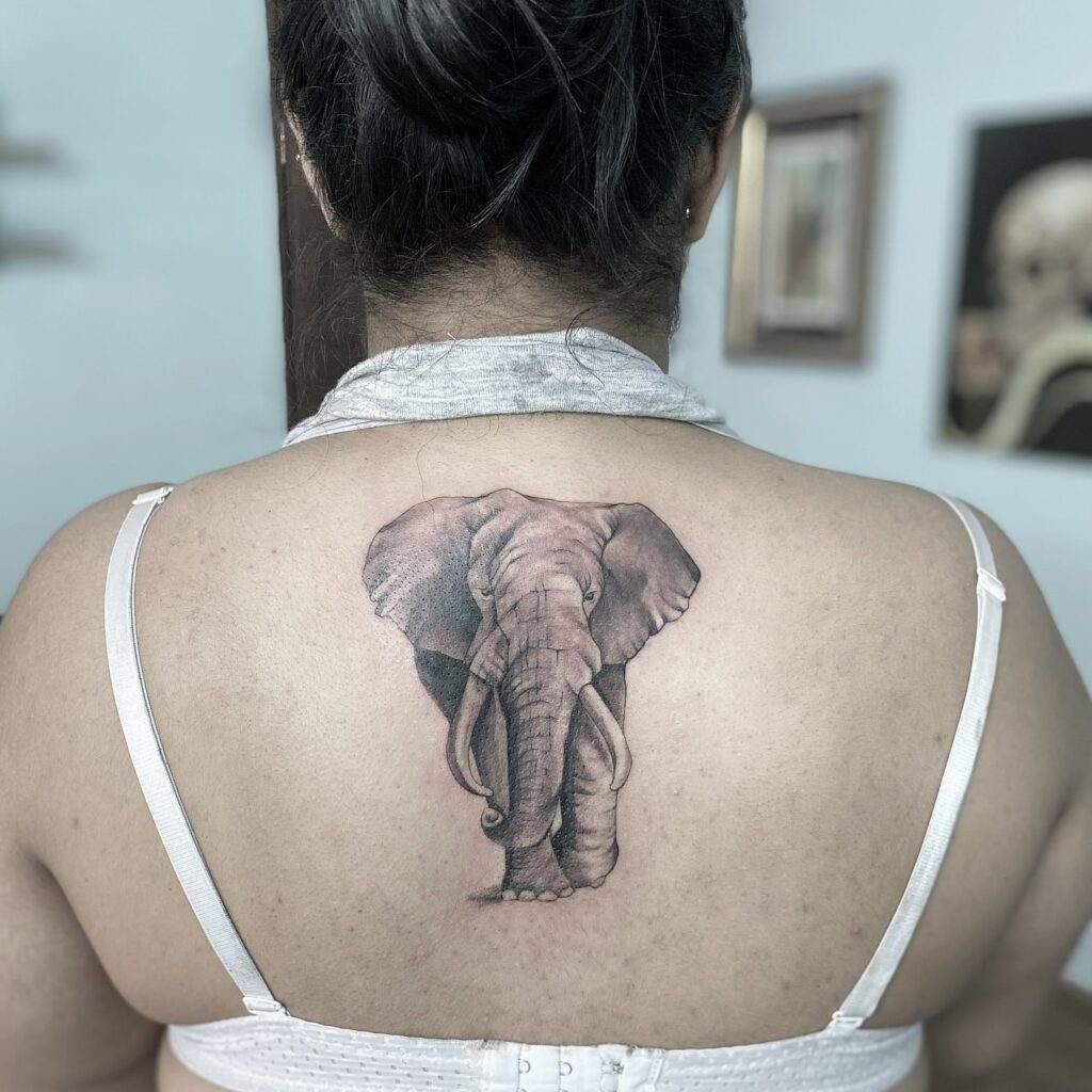 Front side view of elephant tattoo on the back of the neck, realistic black and grey beauty African elegance