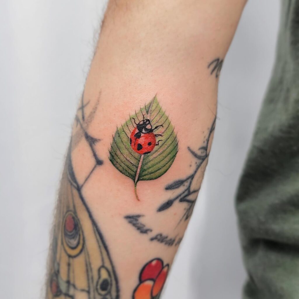 Fronthand Ladybug Tattoo Design With Leaf