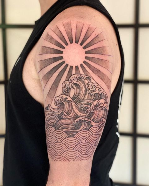 Fully shaded sun and wave tattoo on arm for man image