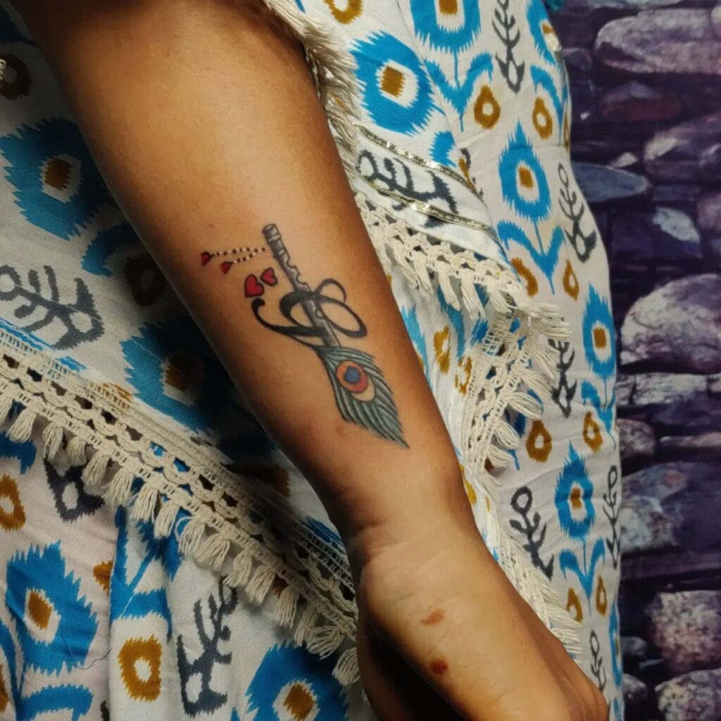 Glorious outer forearm peacock feather tattoo with 'g' text a symbolic choice for women