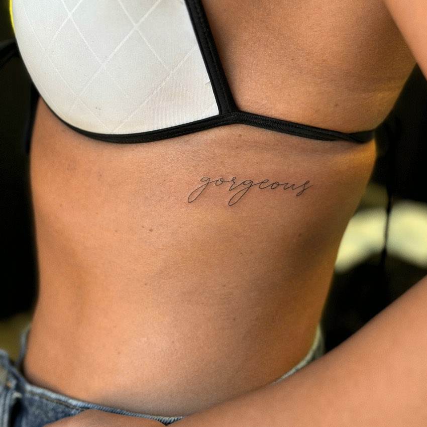 Gorgeous script lettering tattoo on the rib for a timeless design scripted beauty