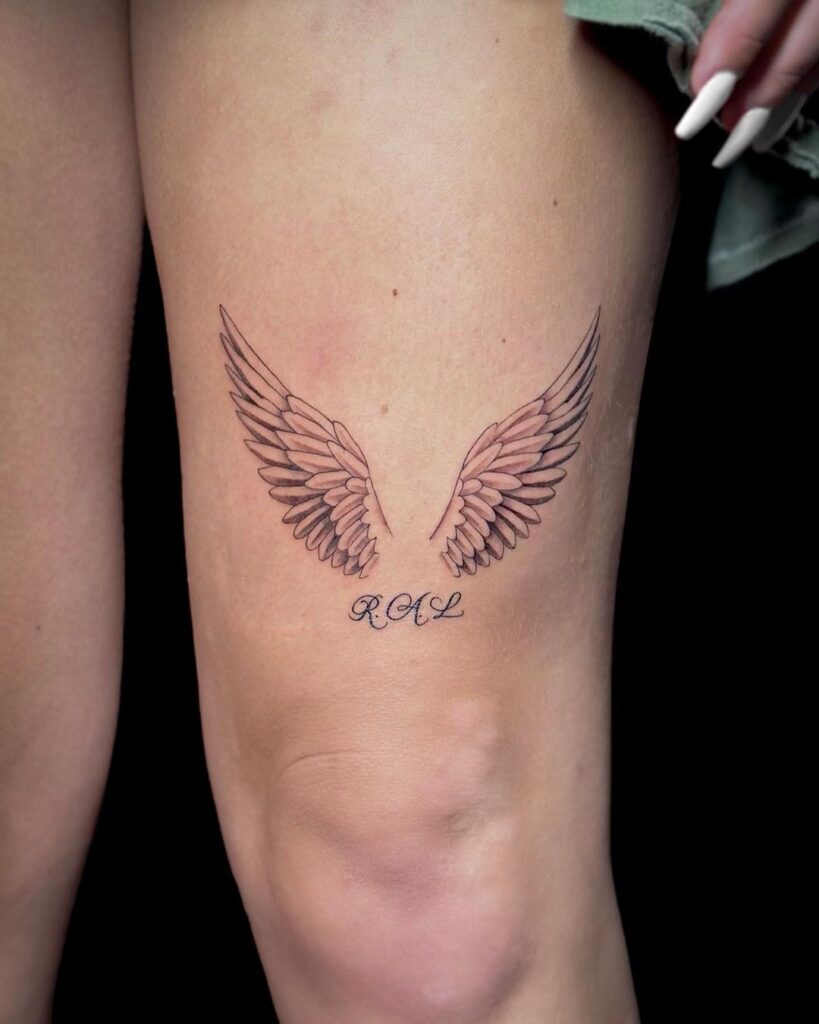 Graceful adornment thigh tattoo with wings