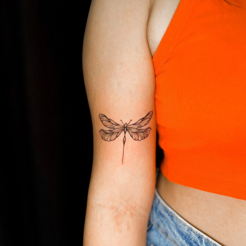 Graceful Fine-Line Dragonfly Tattoo on Upper Arm for a Timeless Look