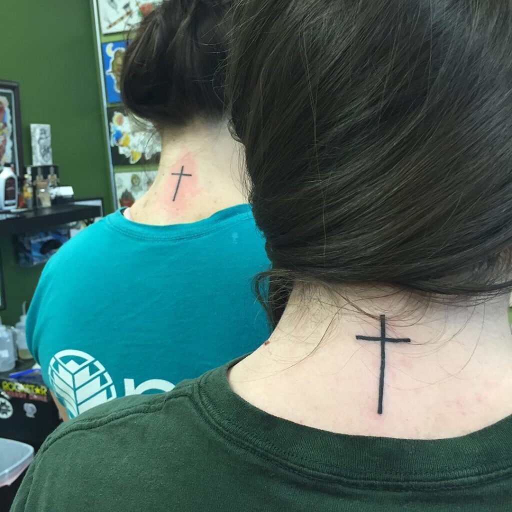 Graceful neck ink tiny cross tattoo on the back of a girl's neck