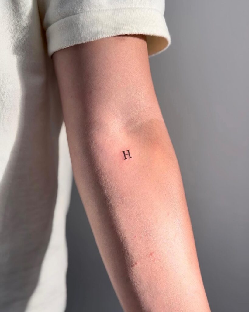 'H' Lettering Tattoo Below the Elbow for Girls: Arm Adornment