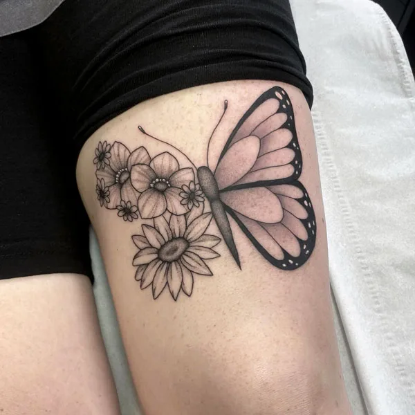 Half butterfly half flower thigh tattoo
