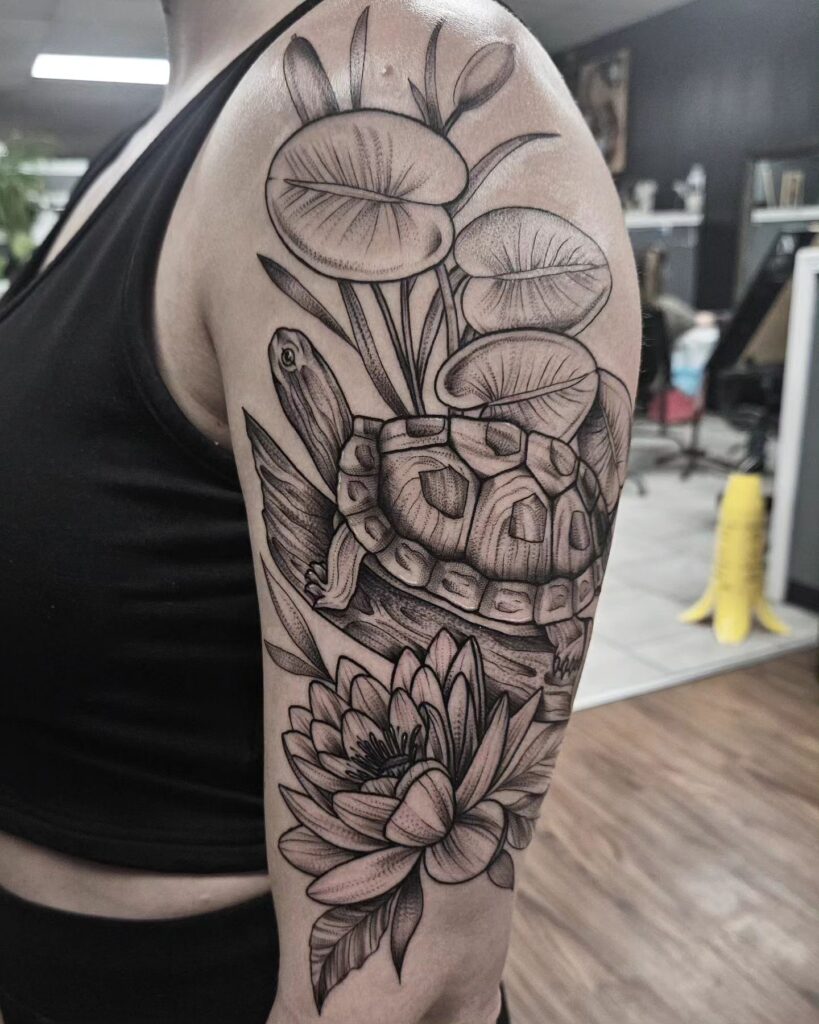 Half sleeve bicep tattoo turtle with floral embellishments