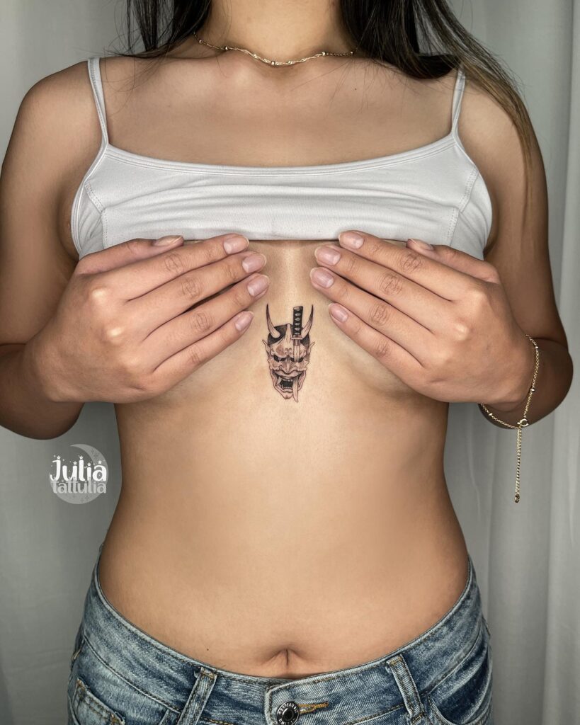 Hannya mask and sword sternum tattoo representing strength and resilience