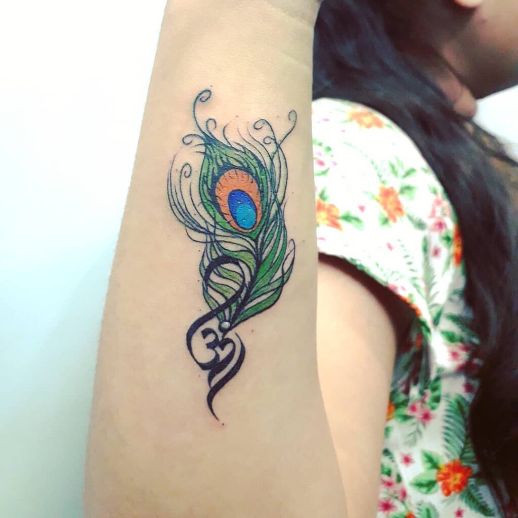 Harmony of symbols outer forearm peacock feather tattoo with om symbol for women