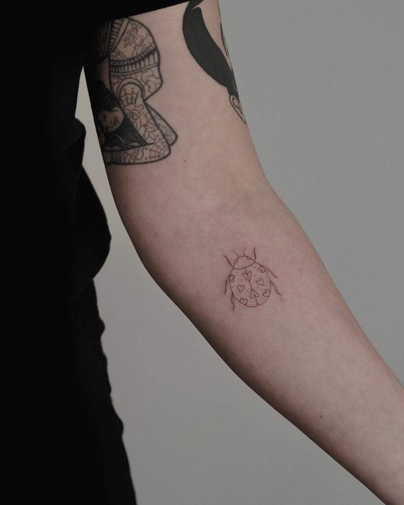 Hearty Ladybug Fineline Tattoo on the Below the Elbow: Whimsical Luck