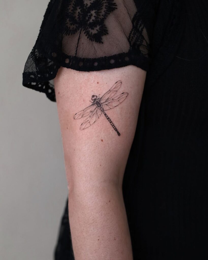 Highly Detailed Dragonfly Upper Arm Tattoo with Elegant Fine Linework