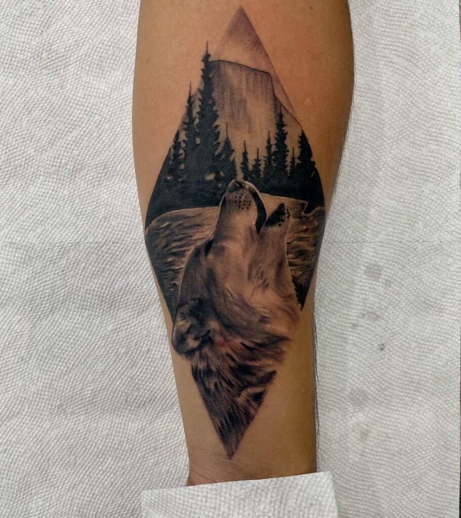 Howling lone wolf on the forearm over scars symbol of resilience