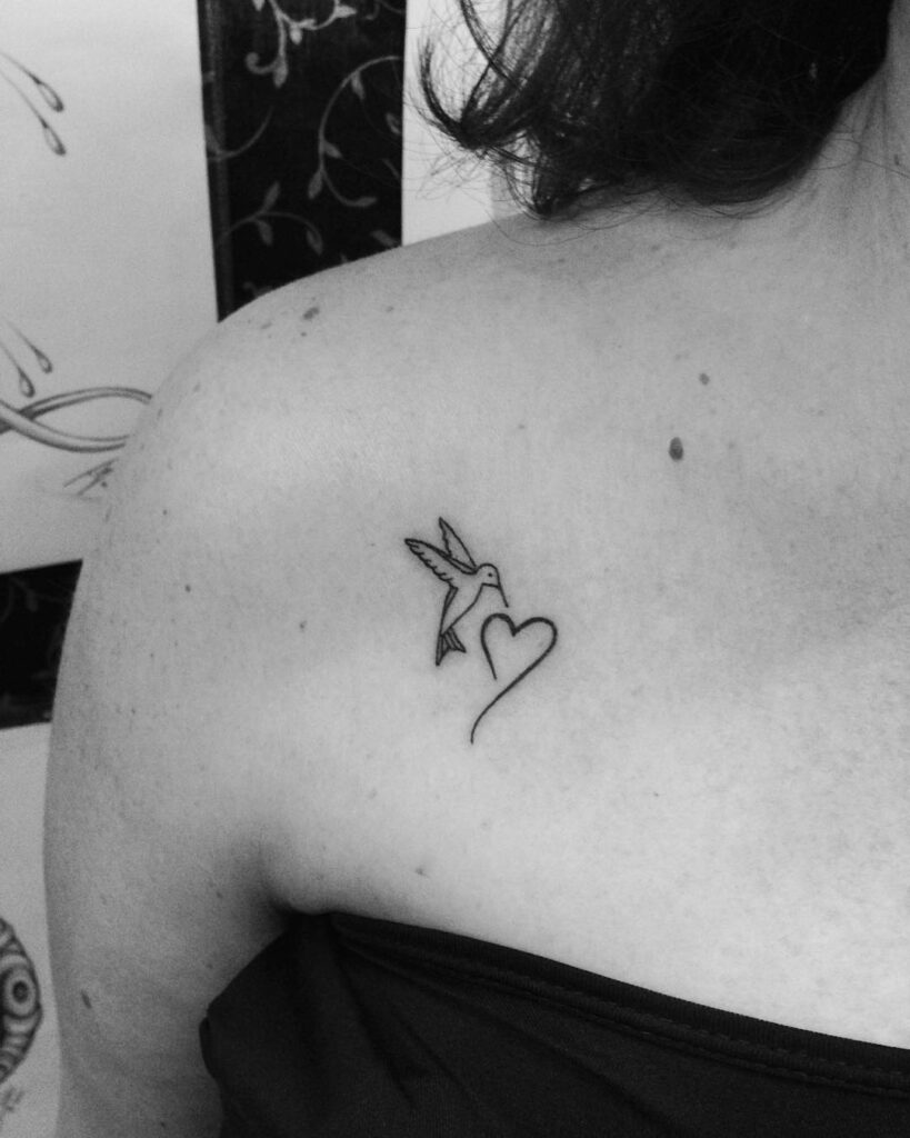 Hummingbird with outline love heart tattoo on collarbone grace and beauty