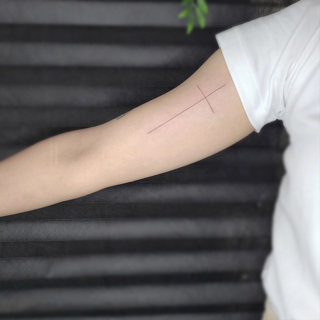 Inner Bicep Thin Line Cross Tattoo Idea for Girl Subtle Charm